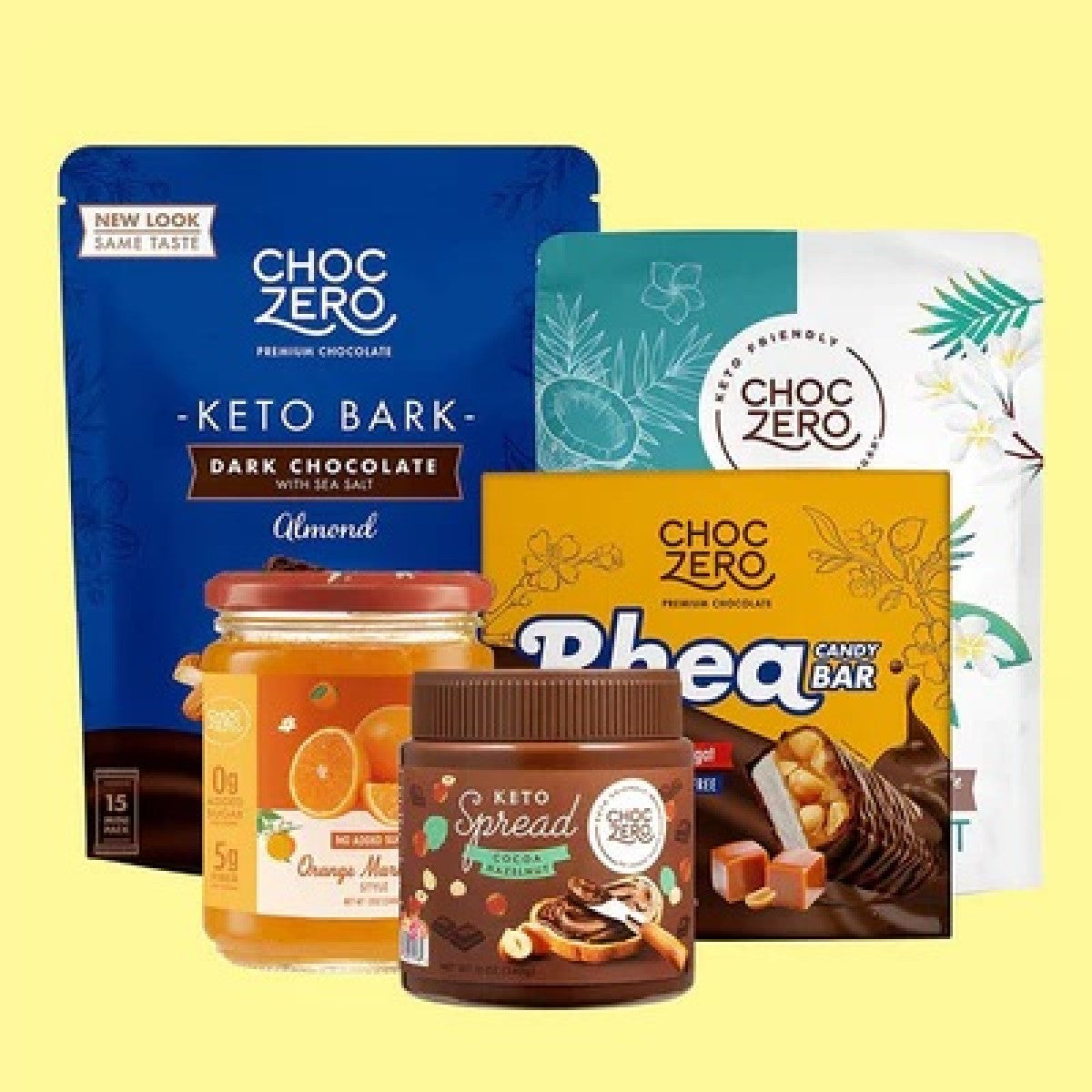 A collection of ChocZero products, including Keto Bark, a jar of orange marmalade, a chocolate spread, and a candy bar, displayed against a light yellow background.