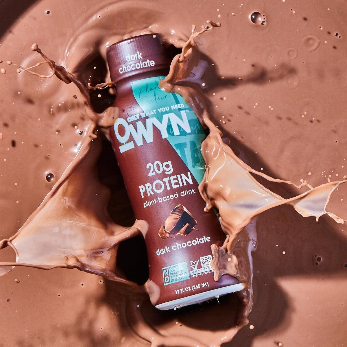 A bottle of OWYN dark chocolate protein drink is splashing into a pool of chocolate liquid, highlighting its plant-based ingredients and 20 grams of protein.