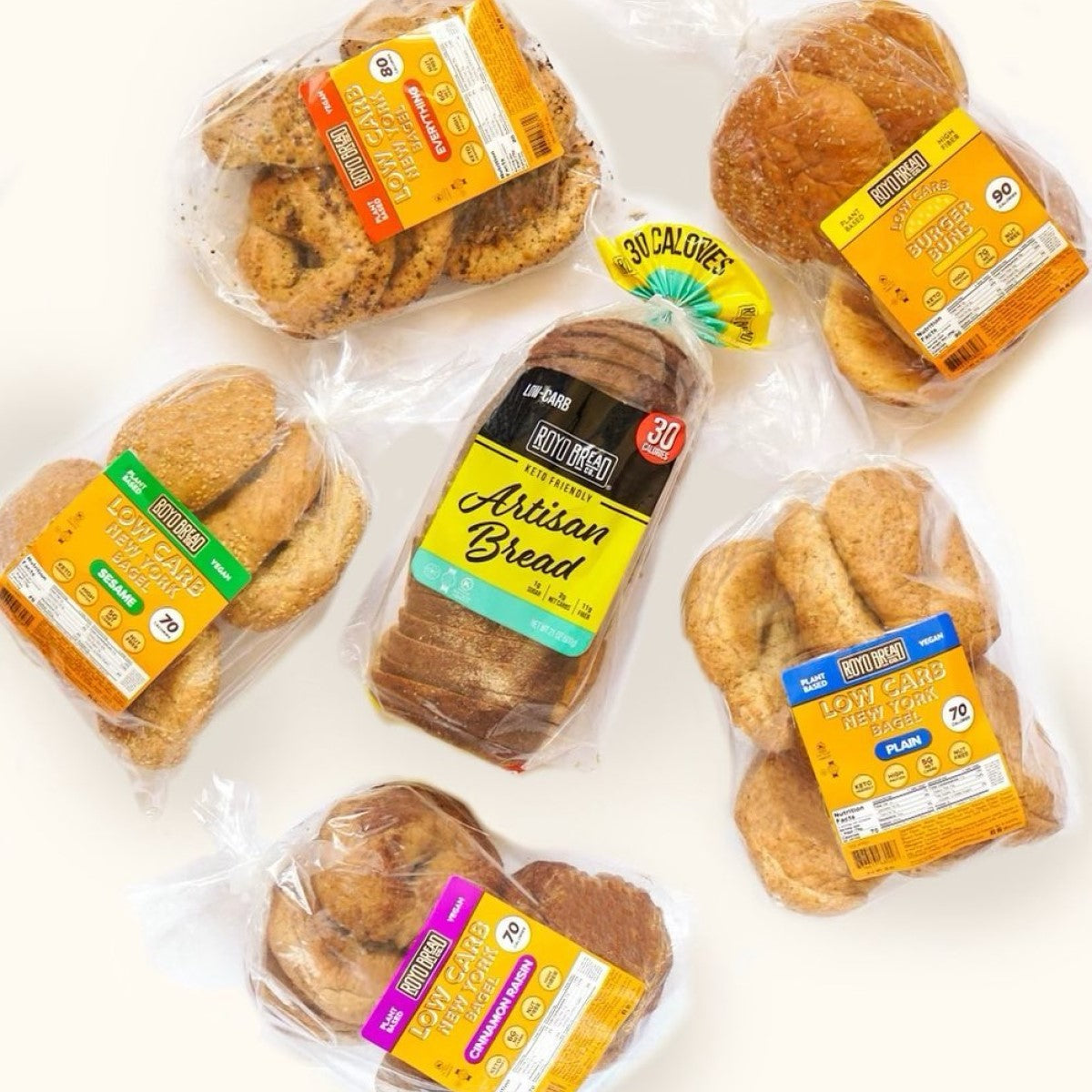 A variety of Royo Bread Company products, including low-carb bagels and artisan bread, are displayed in clear packaging, showcasing colorful labels with nutritional information.