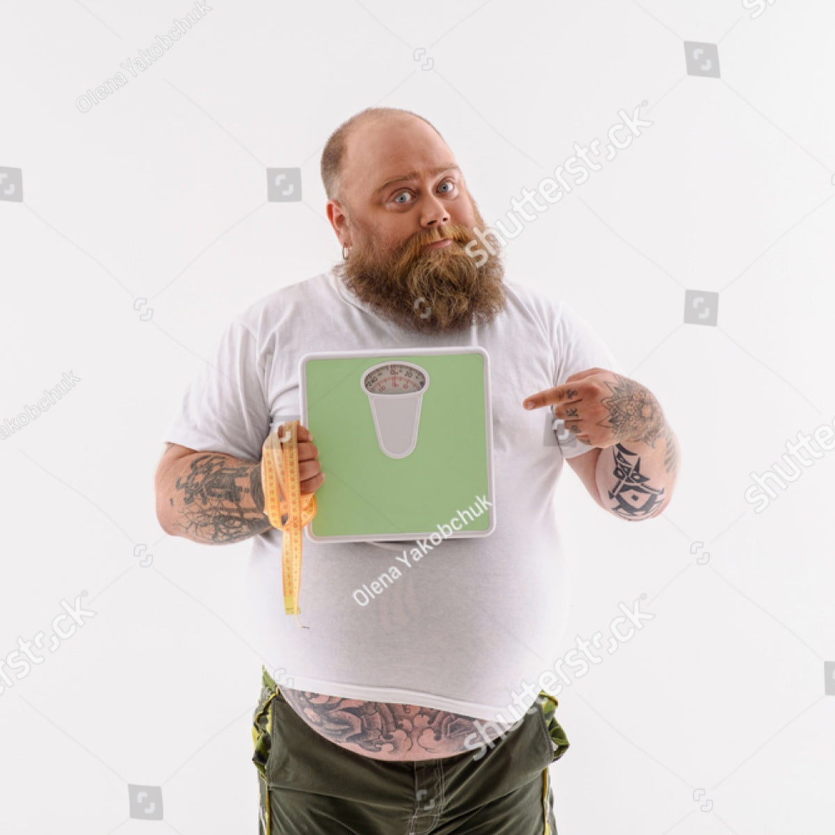 A bearded man in a white shirt holds a scale graphic while pointing at it, with a measuring tape draped over his arm, standing against a plain white background, suggesting a weight loss journey.