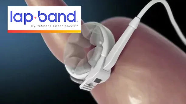 A close-up of a finger holding a Lap-Band® device, which is a flexible gastric band, connected to a tube, set against a blurred background, illustrating its design and function for weight management.