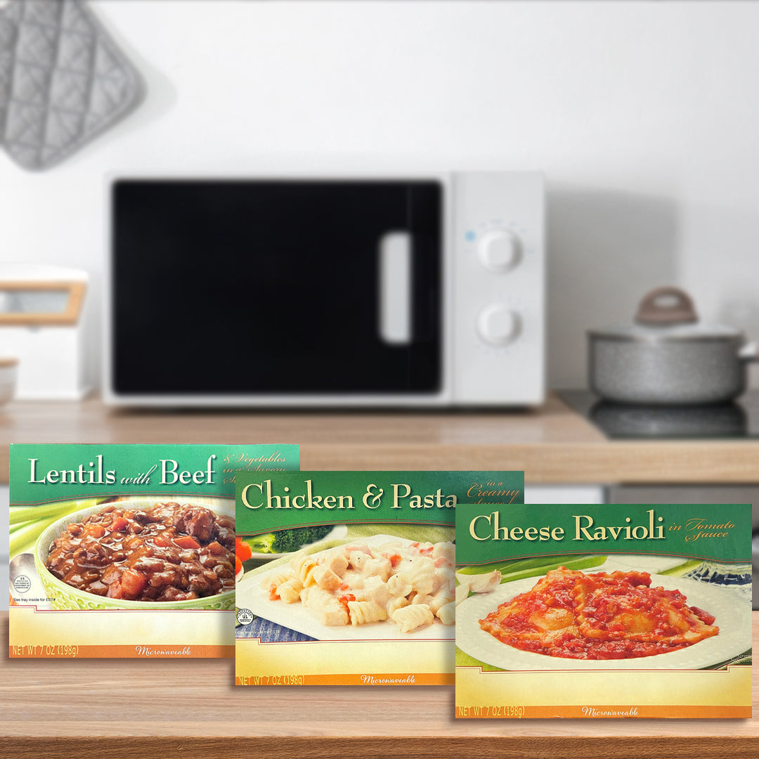 Three microwavable protein entrees—Lentils with Beef, Chicken & Pasta, and Cheese Ravioli—are displayed on a kitchen countertop with a microwave in the background.