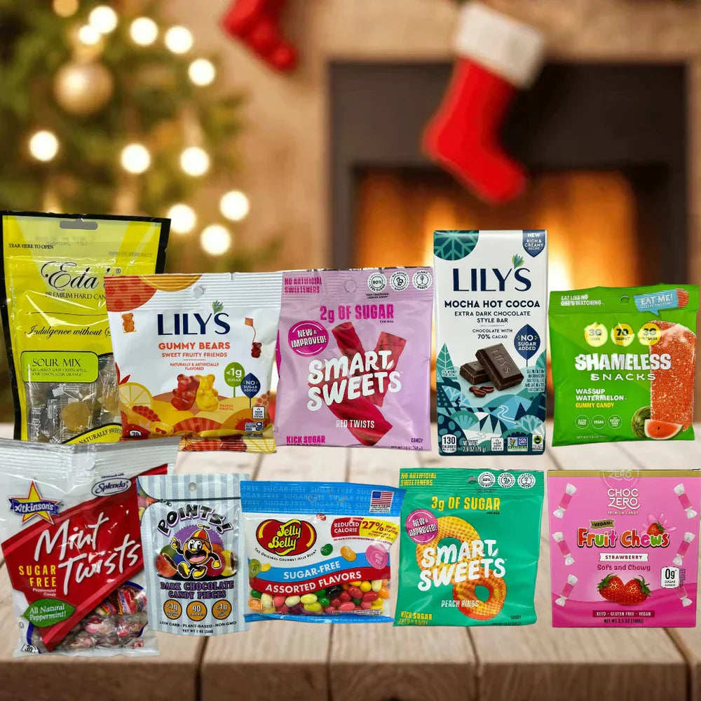 A festive assortment of candy packages, including gummy bears, chocolate bars, and sugar-free options, is displayed on a wooden table with a decorated Christmas tree and stockings in the background.