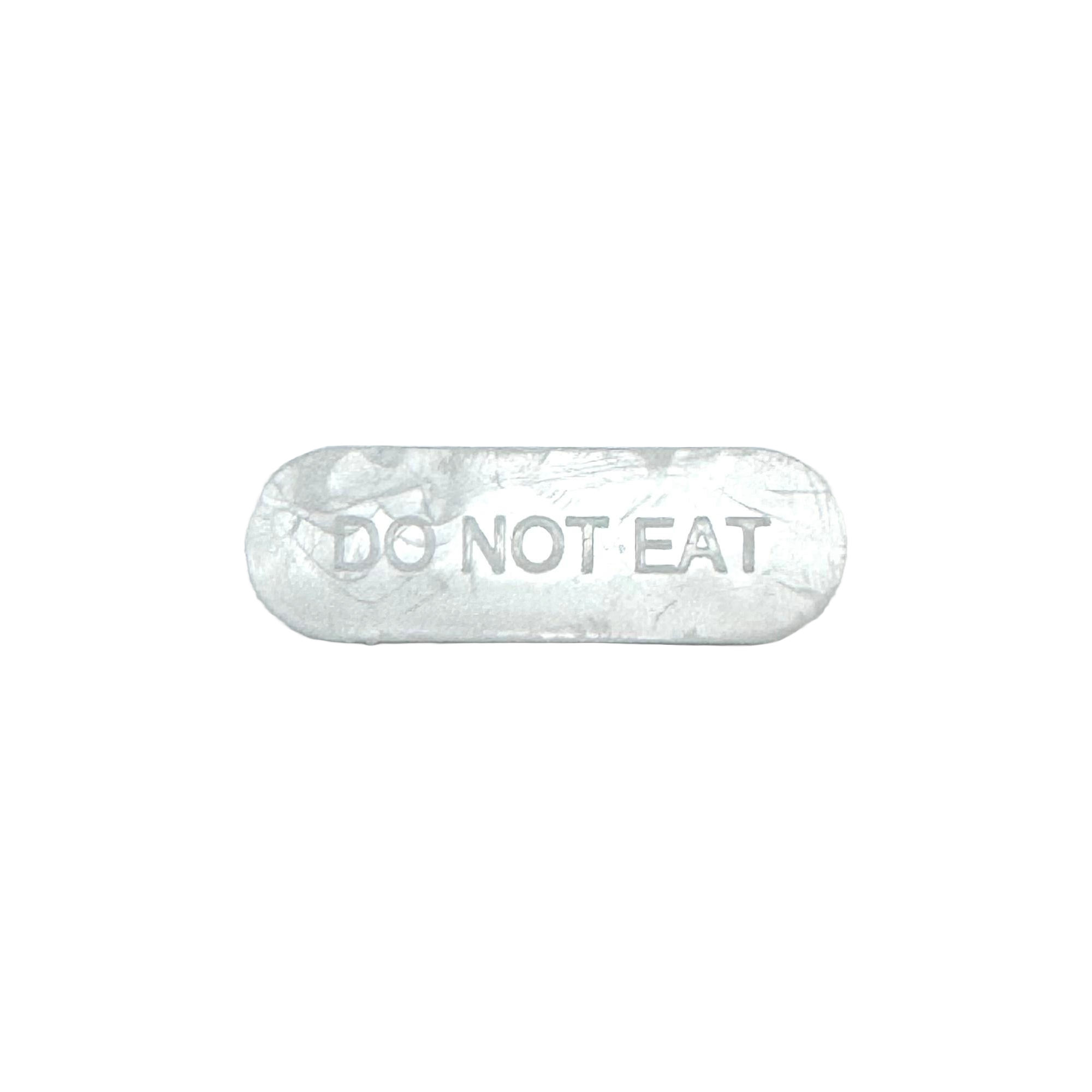A white, oval-shaped object with the words "DO NOT EAT" embossed on its surface, typically used as a packaging warning in ecommerce products.