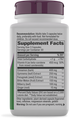 A white supplement bottle with a purple lid displays the supplement facts label, listing ingredients like Vitamin A, cinnamon, and ginger, along with dosage recommendations and a warning for pregnant individuals.
