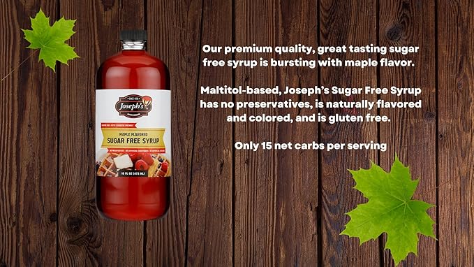 A bottle of Joseph's Sugar Free Syrup, featuring a red label and a maple flavor description, is displayed on a wooden surface with green leaves, highlighting its low-carb and gluten-free qualities.