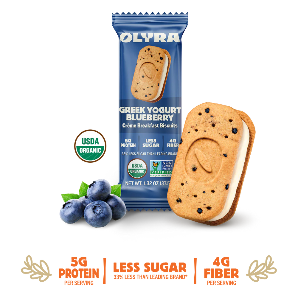 A pack of OLYRA Greek Yogurt Blueberry crème breakfast biscuits is displayed alongside fresh blueberries, highlighting its organic certification and nutritional benefits.