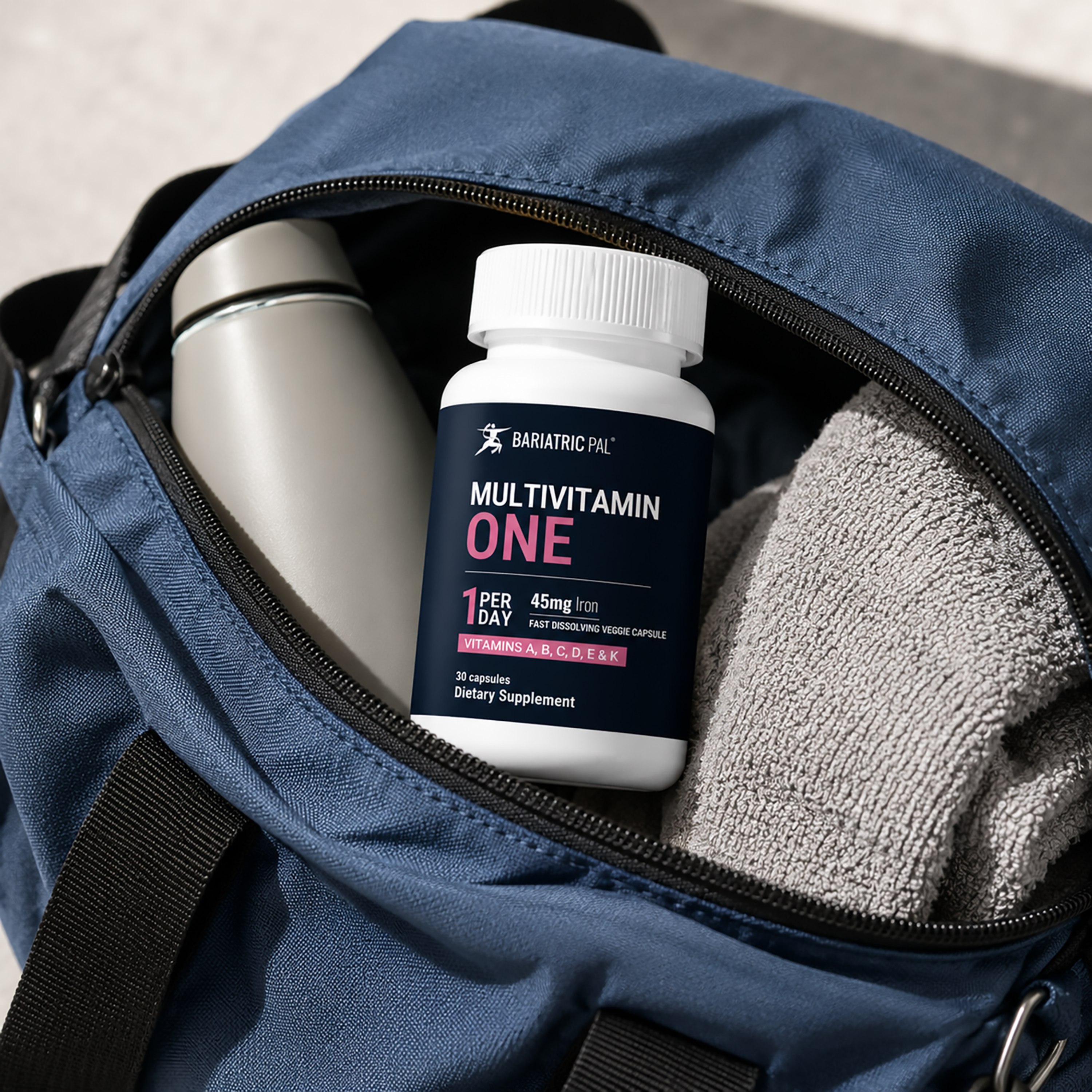 A bottle of BariatricPal Multivitamin ONE with 45 mg of iron, 30 fast-dissolving capsules in a gym bag.
