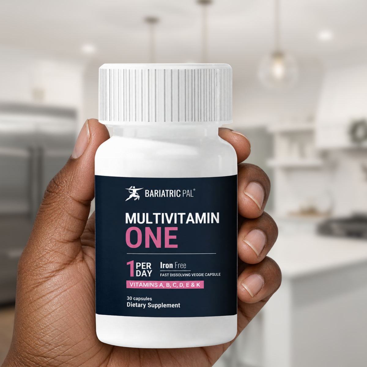 Hand holding bottle of BariatricPal Multivitamin ONE Iron-Free with 30 fast-dissolving veggie capsules. Take one capsule per day.
