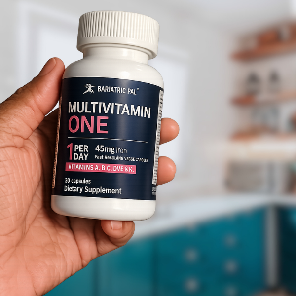 Hand holding a Bariatric Pal Multivitamin One supplement bottle against a blurred background