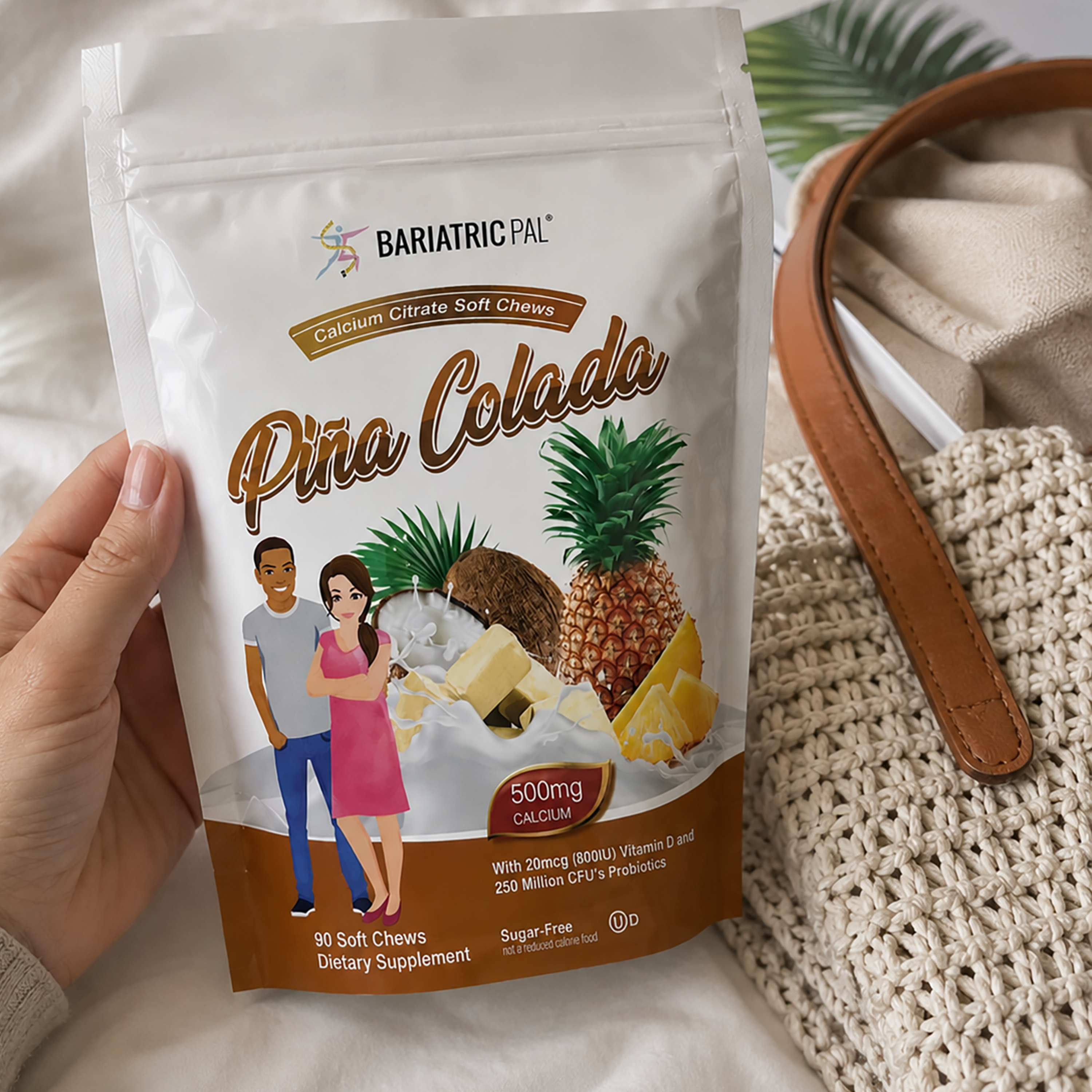 A hand holds a white stand-up pouch of BariatricPal Pina Colada calcium citrate soft chews. The packaging features illustrations of pineapples, a pineapple slice, a couple, and a brown gradient base.