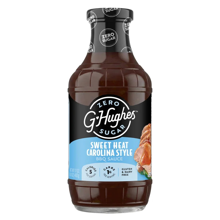 A clear bottle of G. Hughes Sweet Heat Carolina Style BBQ sauce, featuring a black label with white and blue text, displays nutritional information and highlights that it is zero sugar, gluten-free, and dairy-free.