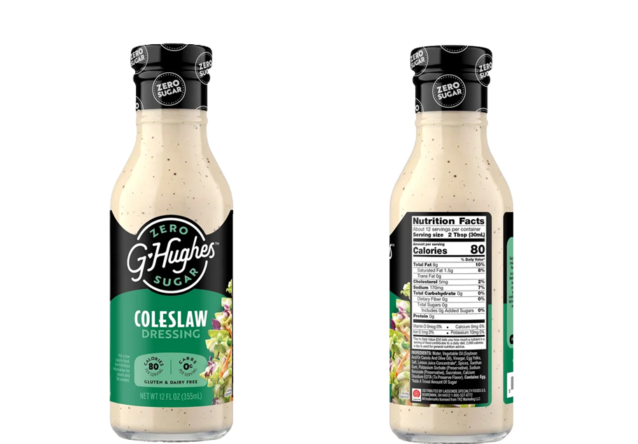 A clear bottle of G. Hughes zero sugar coleslaw dressing displays a creamy beige dressing with a label featuring nutrition facts and a colorful vegetable graphic on the front.