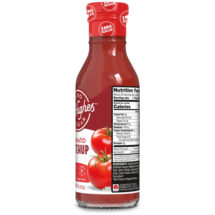 A clear glass bottle of zero sugar tomato ketchup features a red label with white text, displaying the product name and nutrition facts alongside two red tomatoes at the base.