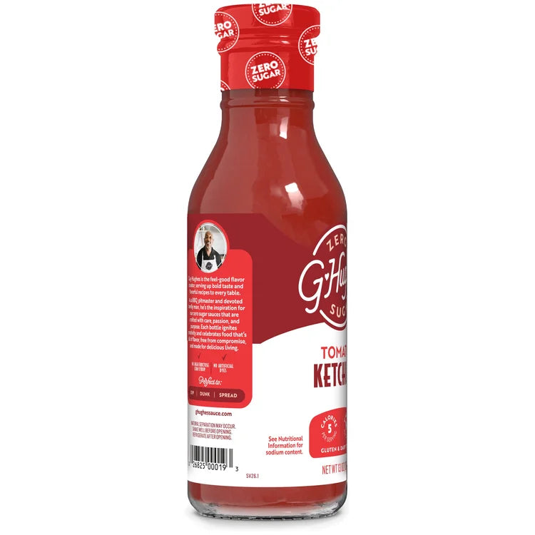 A clear glass bottle of G. Hughes Zero Sugar Tomato Ketchup, featuring a red cap and label, stands upright against a white background, showcasing its branding and nutritional information.