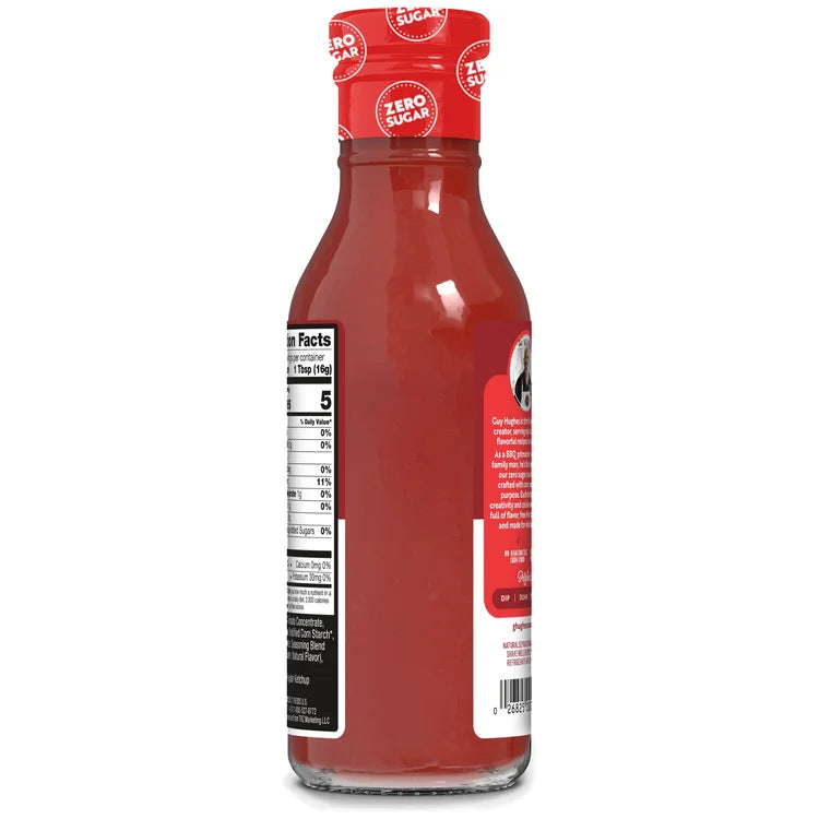 A clear glass bottle of zero-sugar ketchup with a red cap, displaying a nutrition facts label on the back and a branding label featuring a logo on the side.