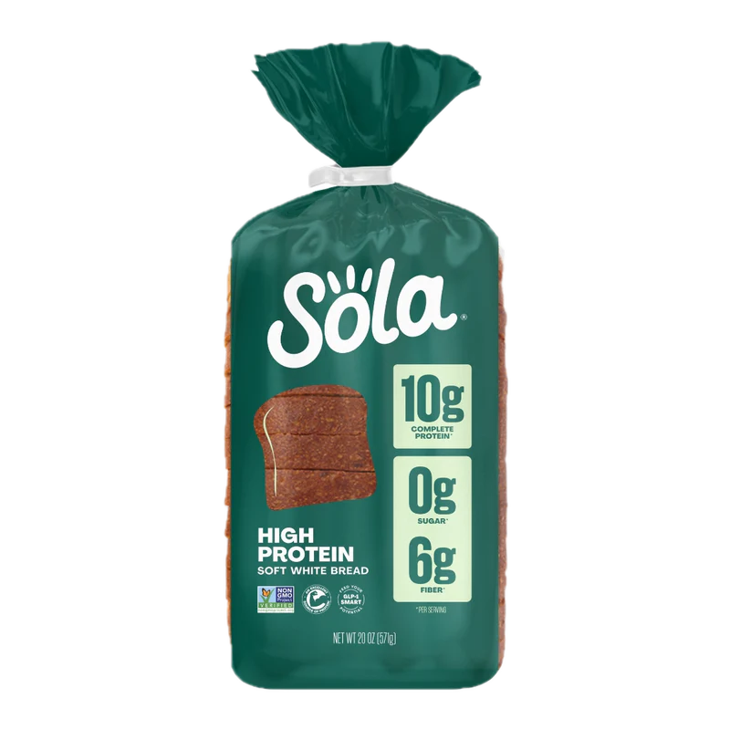 A package of Sola High Protein Soft White Bread shows a dark green bag with the brand logo, nutritional claims of 10g protein, 0g sugar, and 6g fiber, and a slice of bread illustration on the front.