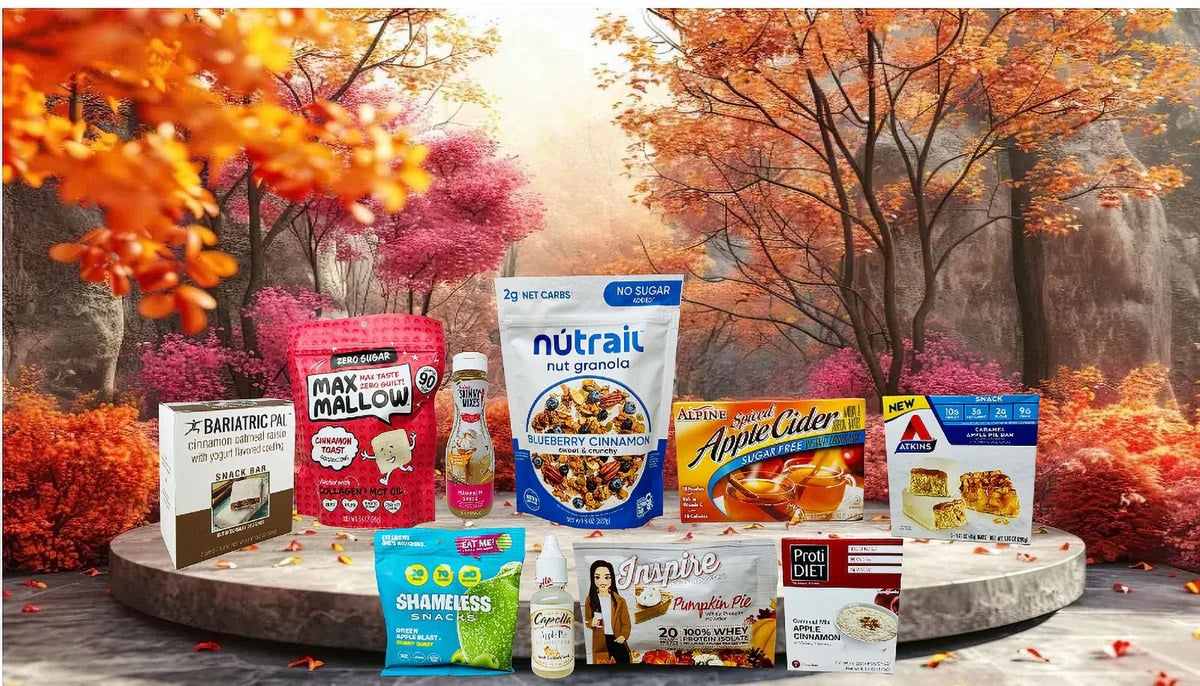 An assortment of autumn-themed snacks, including granola, snack bars, and flavored drinks, is displayed on a circular platform surrounded by colorful fall foliage.