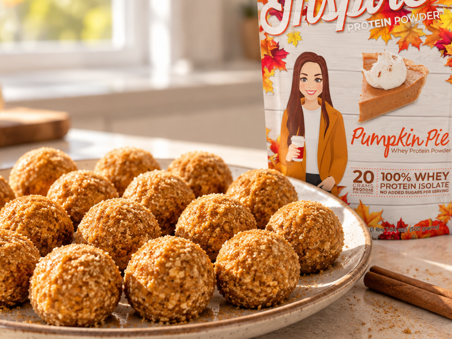 No-bake pumpkin protein balls coated in golden sugar crystals on a speckled ceramic plate, featuring Inspire Pumpkin Pie Whey Protein Powder, with cinnamon sticks and cozy fall decor in a sunlit kitchen.