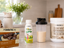 BariatricPal 30g Protein Power Pro Shot, Clean Whey Protein 25g Vanilla, and 15g Dark Chocolate Marshmallow S’mores Protein Bars arranged with a prepared protein shake on a bright kitchen countertop.