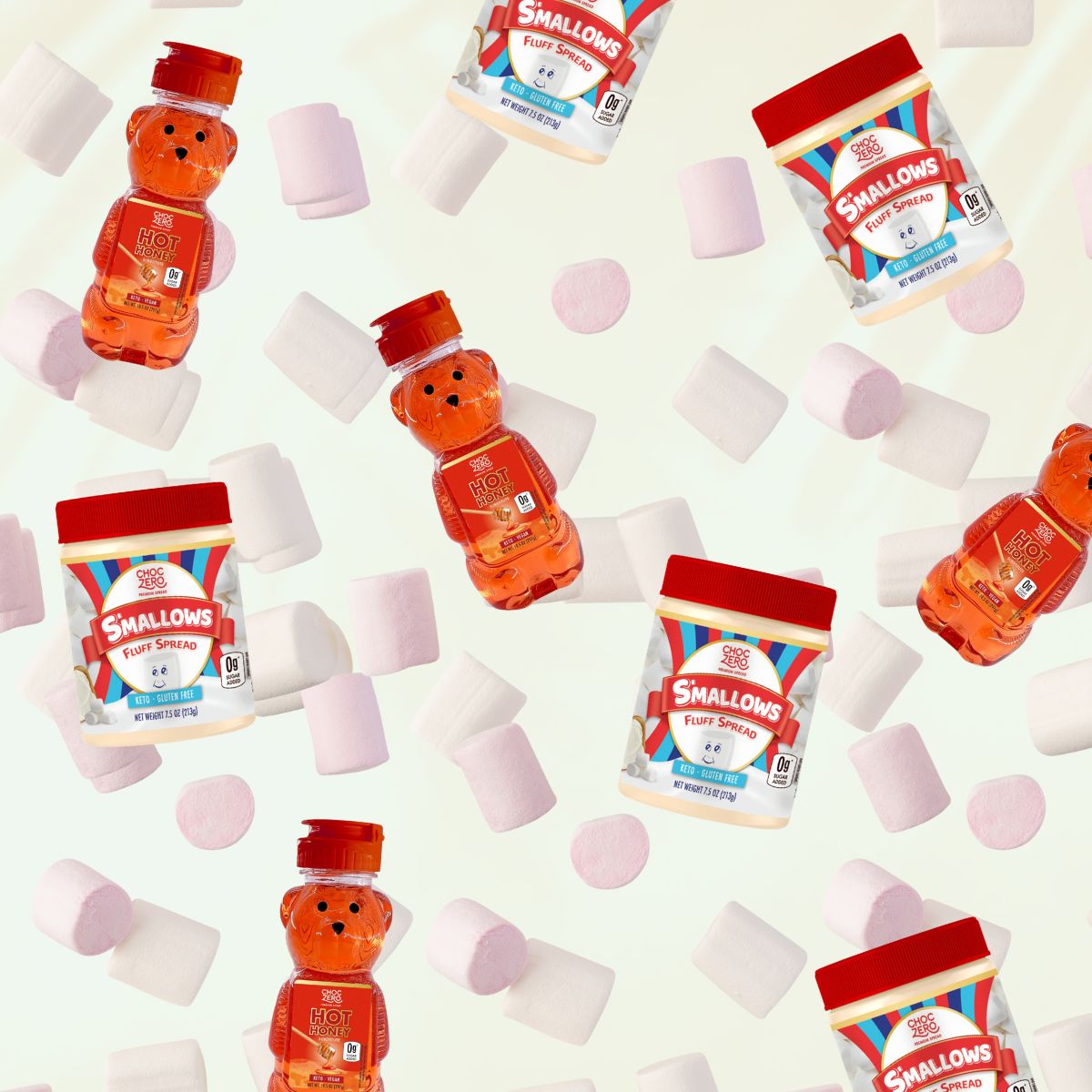Colorful jars of ChocZero's Smallows Fluff Spread and Hot Honey, shaped like a bear, are surrounded by scattered pink and white marshmallows on a light background.