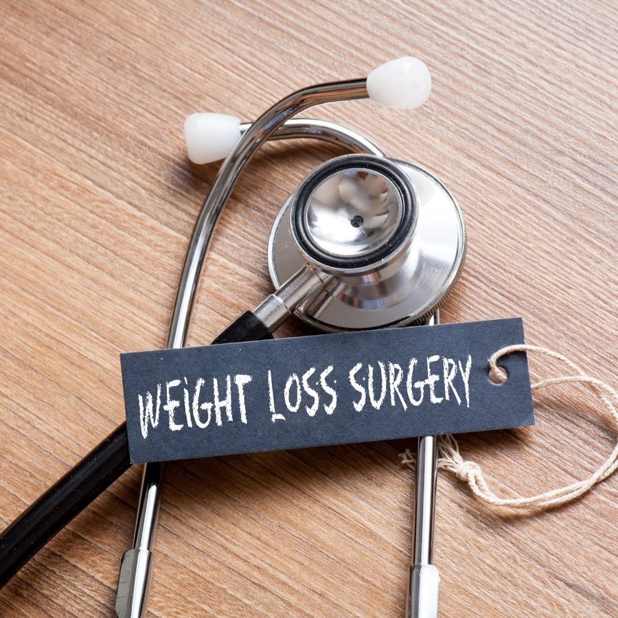 A stethoscope rests on a wooden surface next to a tag that reads "WEIGHT LOSS SURGERY," highlighting a medical context related to weight loss procedures.