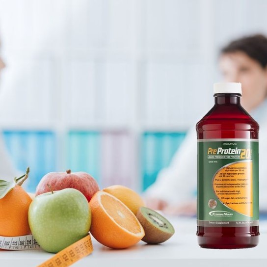 A bottle of Pre-Protein dietary supplement sits on a table surrounded by fresh fruits, while two people engage in conversation in the background, suggesting a focus on health and nutrition.