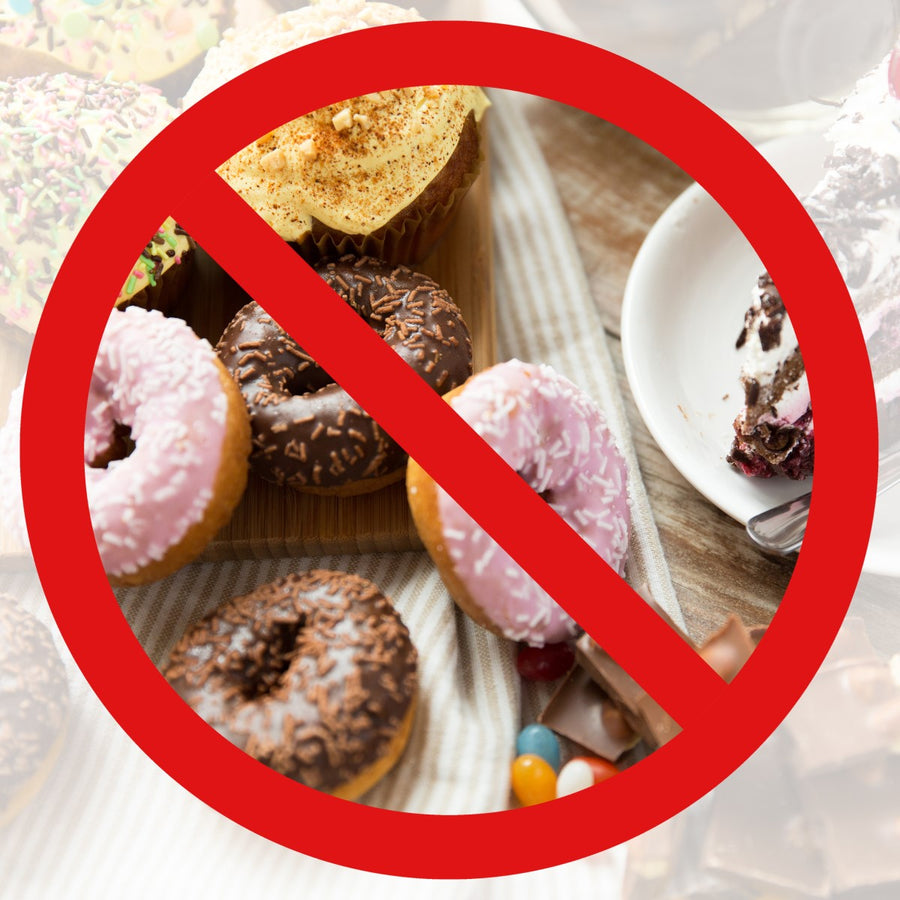 A red "no" symbol overlays a spread of various sweet treats, including donuts and cupcakes, highlighting foods to avoid for managing Dumping Syndrome.