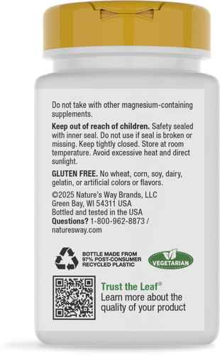 A white supplement bottle with a yellow cap displays safety instructions, warnings about magnesium, and details about gluten-free and vegetarian content, along with contact information for the manufacturer.