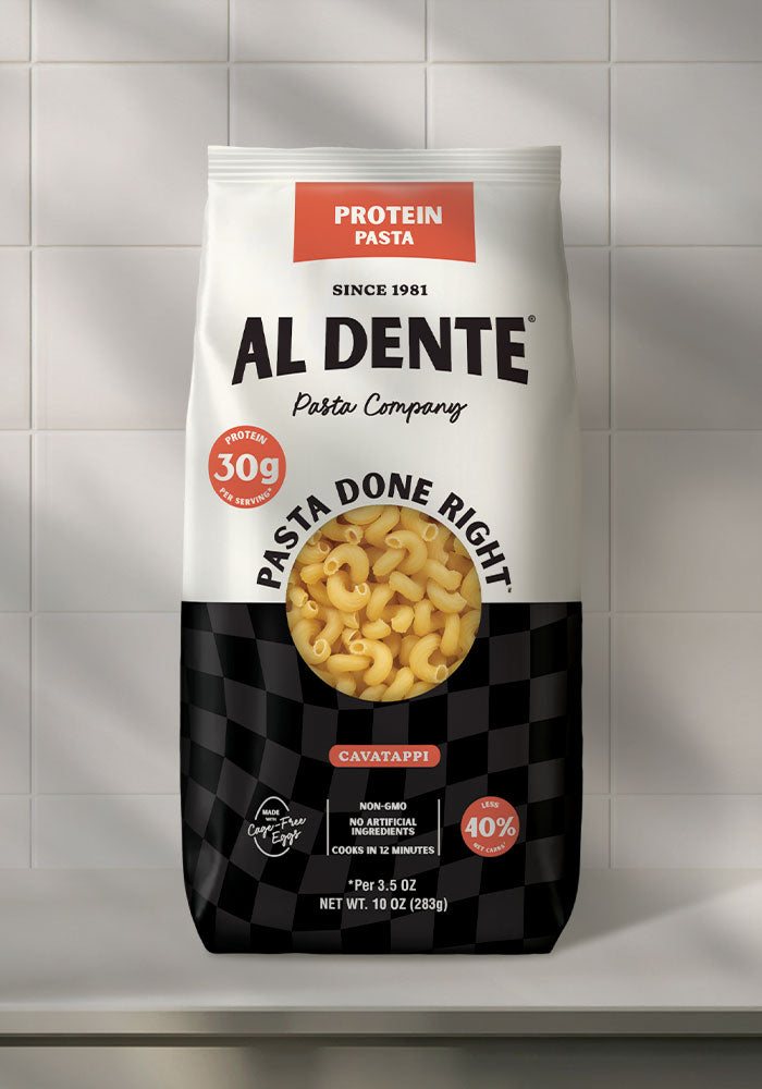 A bag of Al Dente protein pasta, featuring cavatappi noodles, displays nutritional information highlighting 30g of protein per serving and cooking instructions against a checkered black and white background.