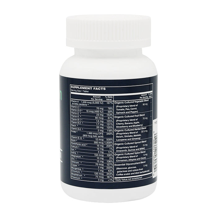 A white supplement bottle with a black label displays detailed supplement facts, including vitamins and organic blends, emphasizing its nutritional content and serving size of one tablet.