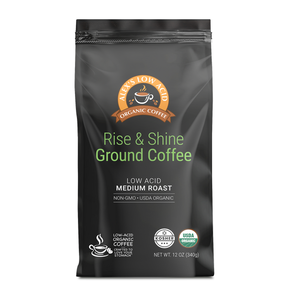 A black coffee bag labeled "Rise & Shine Ground Coffee," featuring the brand name, highlights its low acid, medium roast, and organic certifications, with a net weight of 12 oz.