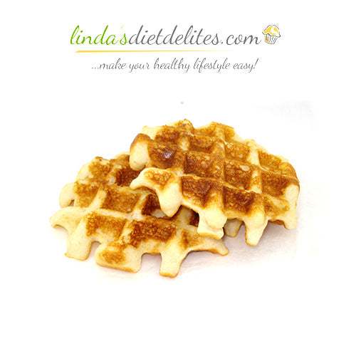 Golden-brown waffles are stacked on a white surface, showcasing their crispy texture and grid pattern, ideal for a healthy lifestyle.