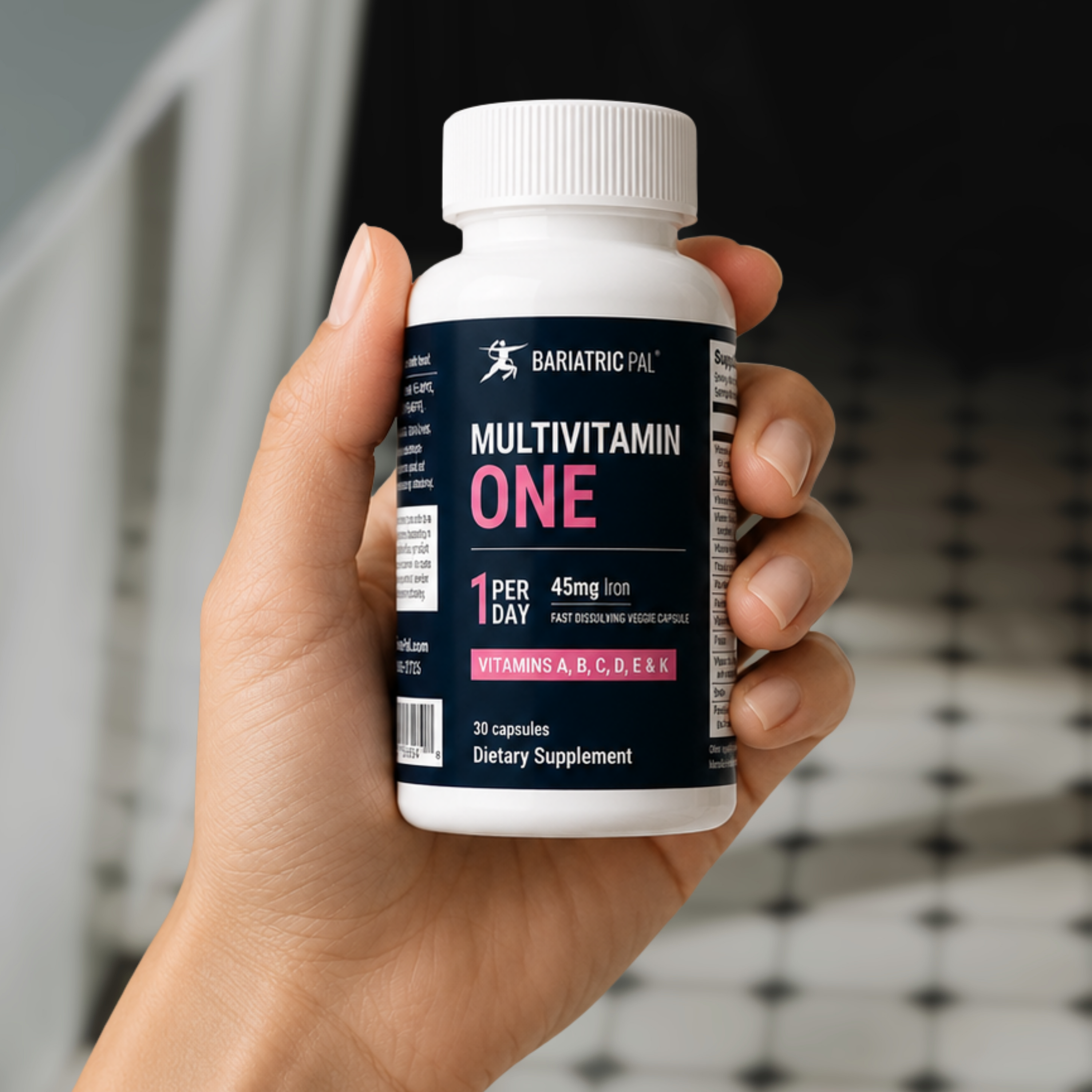 Hand holding a bottle of BariatricPal Multivitamin ONE with 45 mg of iron, 30 fast-dissolving capsules and a once-daily serving.
