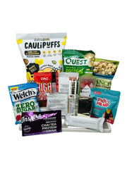 A variety of snack products, including protein bars, chips, and drinks, are arranged on a white tray, showcasing colorful packaging and labels highlighting health benefits and flavors.