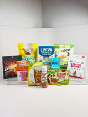 A variety of health and fitness products, including protein powders, snacks, and drinks, are displayed on a clear stand against a plain background, showcasing their colorful packaging.