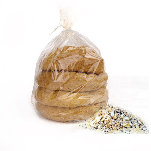 A clear plastic bag contains several stacked cookies, with a small pile of colorful sprinkles beside it on a white background.