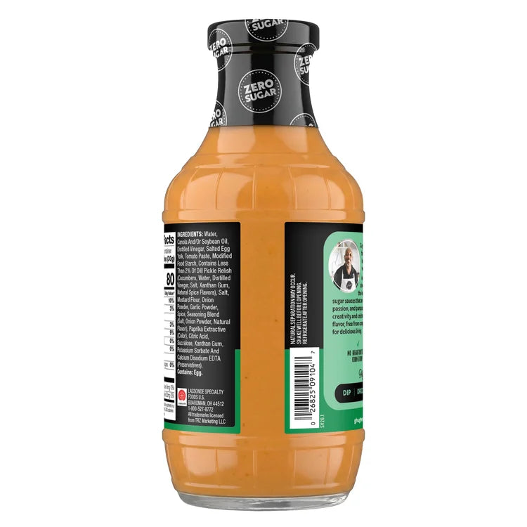 A clear plastic bottle of zero sugar sauce with a brown-orange color, featuring a black cap and a label detailing ingredients and nutritional information on the back.