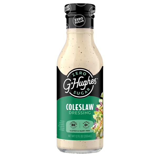 A clear bottle of G Hughes zero sugar coleslaw dressing features a black and green label, highlighting its gluten-free and dairy-free attributes, with a colorful image of salad ingredients.