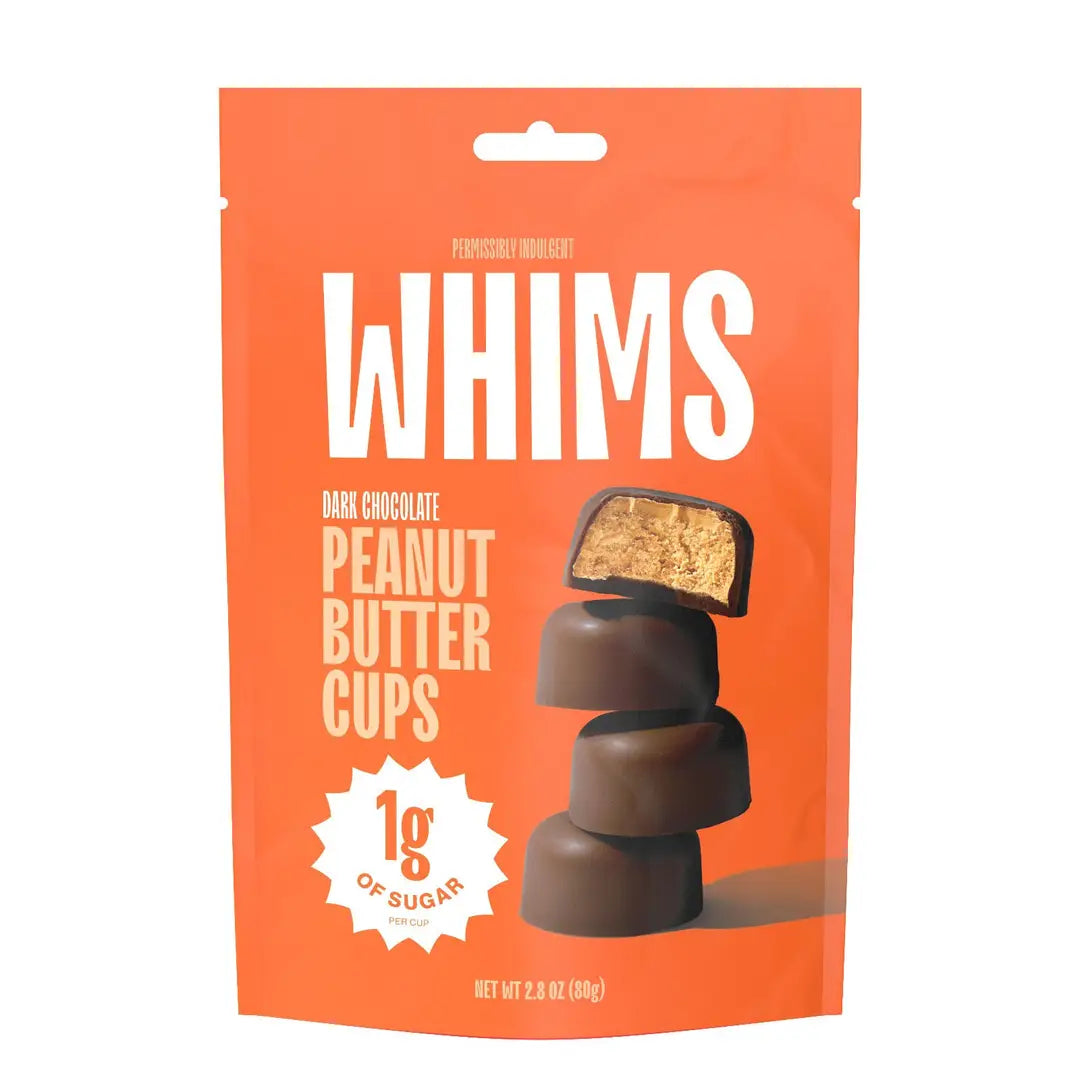 A bright orange package labeled "WHIMS" features dark chocolate peanut butter cups, with one cup cut in half to show the filling, and highlights "1g of sugar per cup."