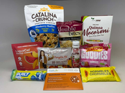 A variety of health-focused food products are displayed, including protein cereals, gummies, pasta, and multivitamins, arranged against a neutral background for an e-commerce presentation.