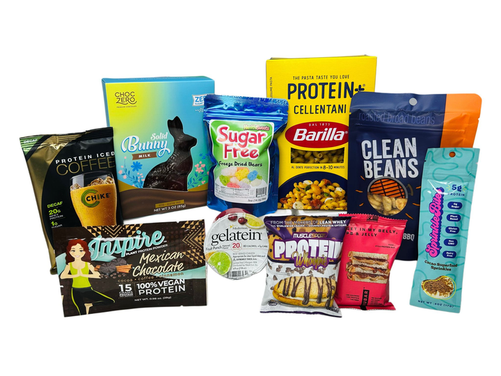 A variety of protein-rich snacks and products are displayed, including chocolate bunnies, protein coffee, and pasta, showcasing colorful packaging and diverse flavors.