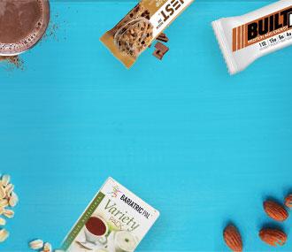 Healthy snack assortment including protein bars and mix packs on blue background